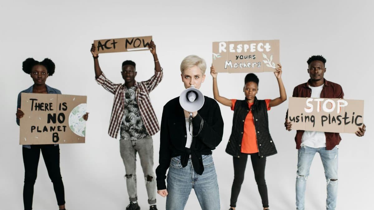 Diverse group of young activists protesting with placards against environmental issues, demanding urgent action.