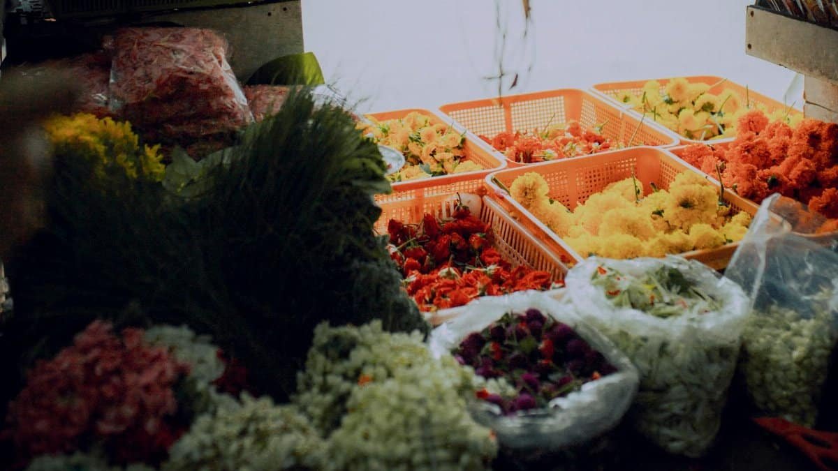 Colorful assortment of fresh flowers in baskets at an outdoor market, showcasing nature's beauty.