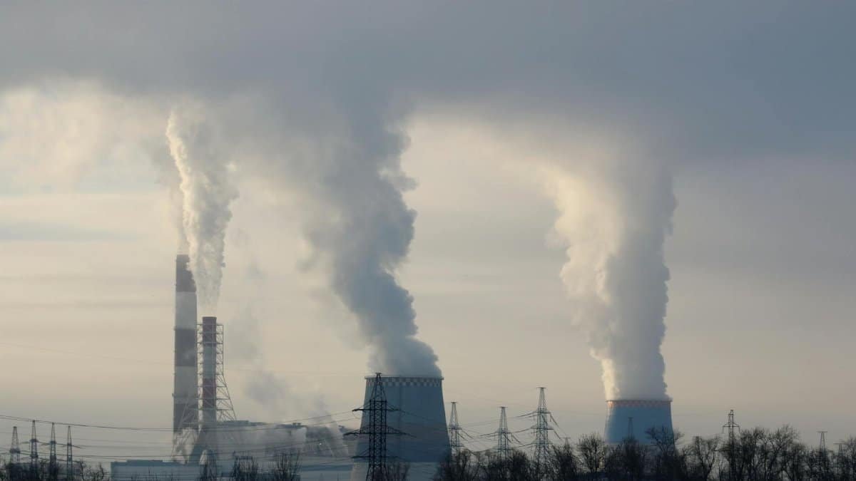 Smoke billowing from industrial smokestacks, contributing to air pollution in the atmosphere.