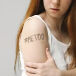 Portrait of a woman with #MeToo written on her arm, symbolizing empowerment and awareness.