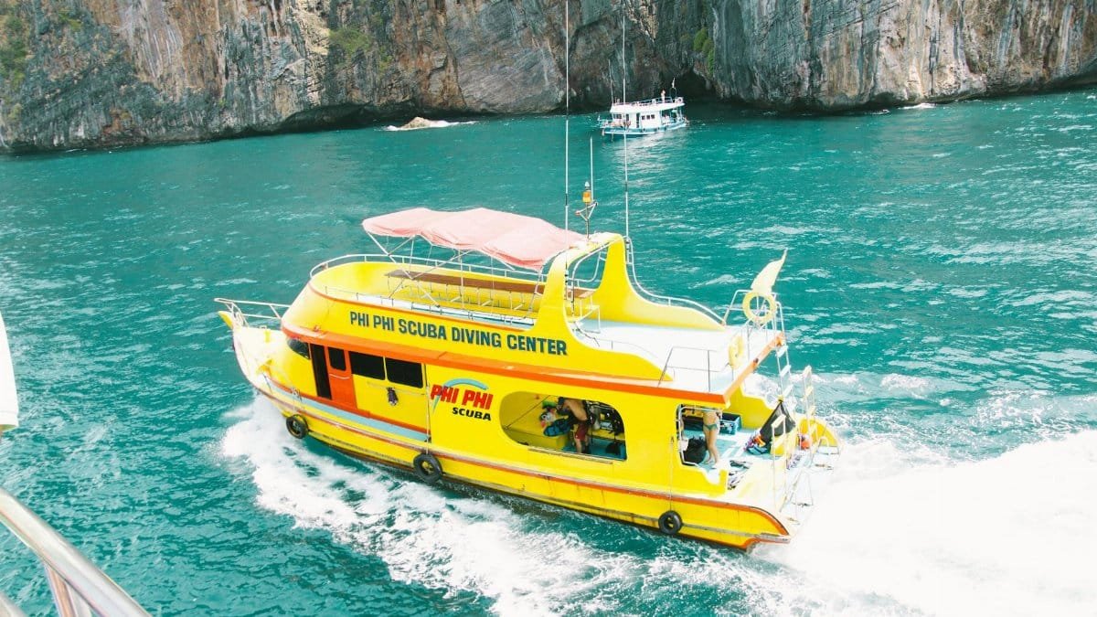 Scuba diving tour boat cruising the turquoise waters of Phi Phi Islands, Thailand.