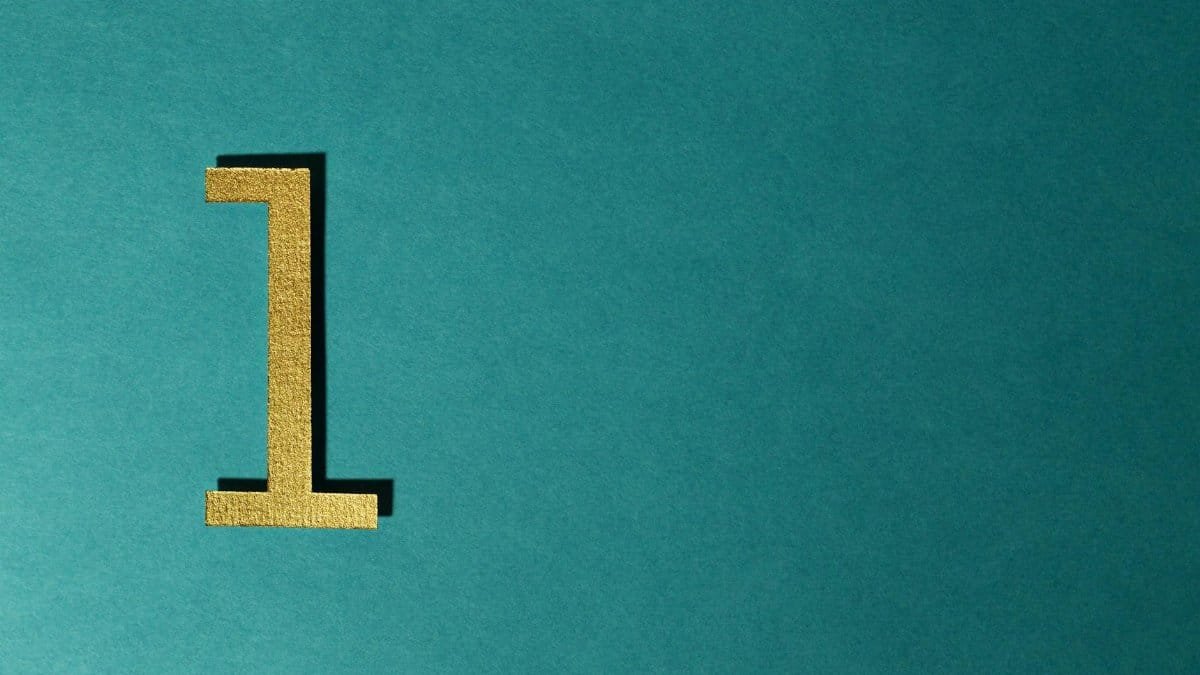 A gold number one on a teal background with ample copy space.