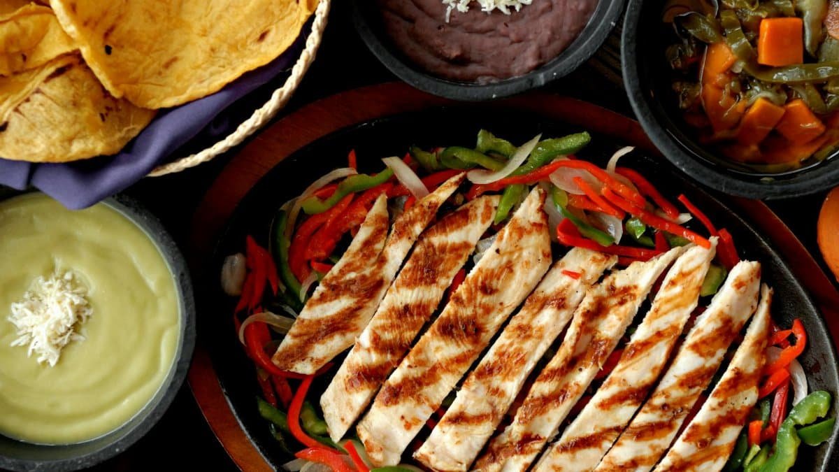 Delicious chicken fajitas with colorful peppers, tortillas, and traditional Mexican sides.