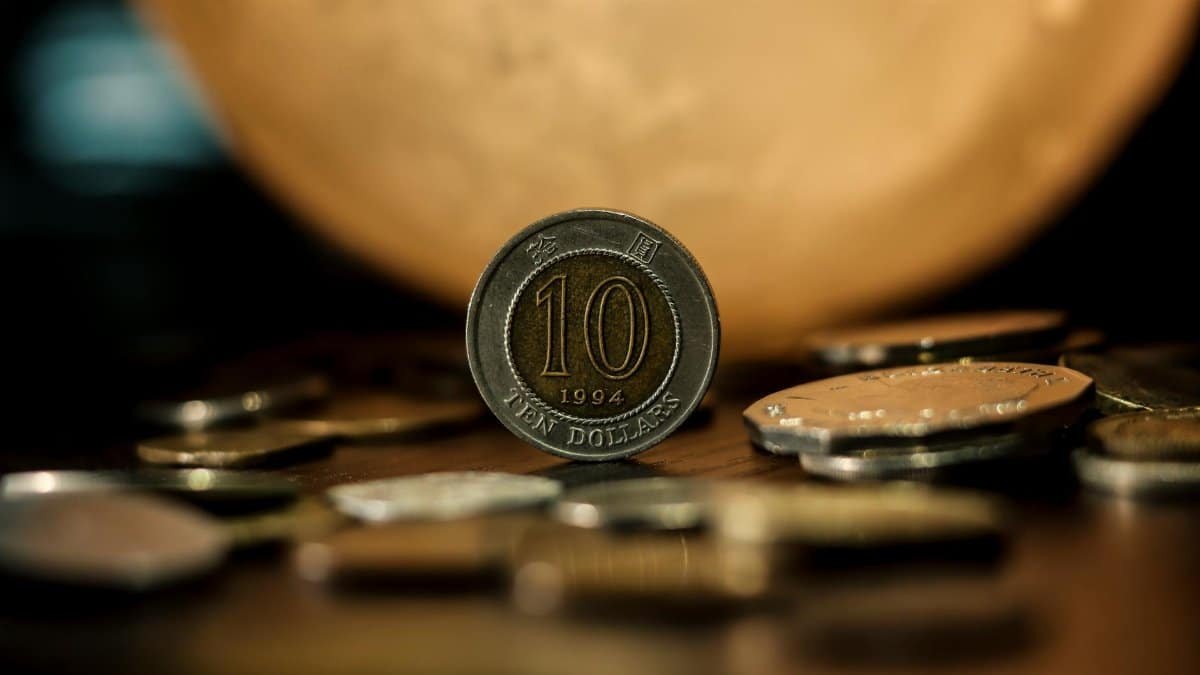 Detailed close-up of a ten dollar coin with a blurred golden background, highlighting currency and finance.