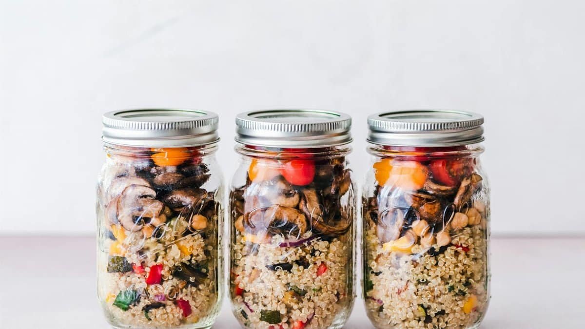 Colorful quinoa salad jar with roasted veggies, ideal for healthy meal prep.