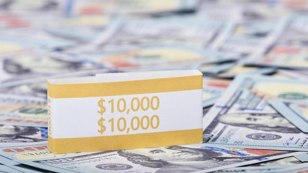 Close-up image of a stack of US dollars with a $10,000 band, symbolizing wealth and finance.