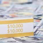 Close-up image of a stack of US dollars with a $10,000 band, symbolizing wealth and finance.