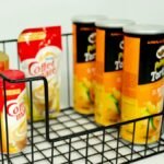 A collection of snack and coffee items in a wire basket on a white background, perfect for pantry organization.