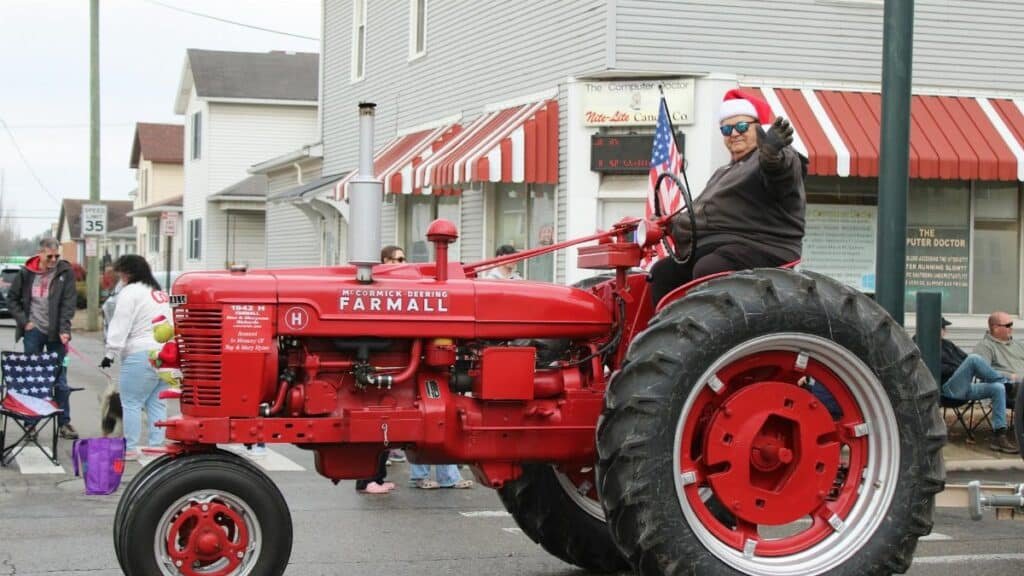 Celebratory Christmas parade featuring a vintage red tractor in Lancaster, Ohio.