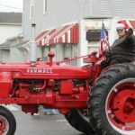 Celebratory Christmas parade featuring a vintage red tractor in Lancaster, Ohio.