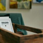 Cozy interior scene with books in a wooden box and abstract art on walls.