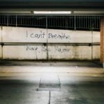 Underpass featuring "I can't breathe" and "Black lives matter" graffiti. Urban setting, social justice message.