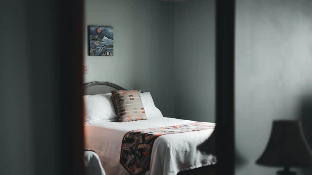 A soothing minimalist bedroom with cozy vibes, featuring a wooden bedframe and subtle decor.