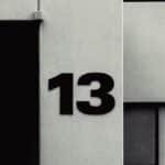 High-contrast facade featuring the number 13 on a modern building exterior.