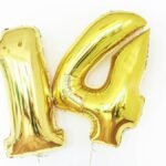 Shiny gold metallic number 14 balloons on a white background, perfect for celebrations.