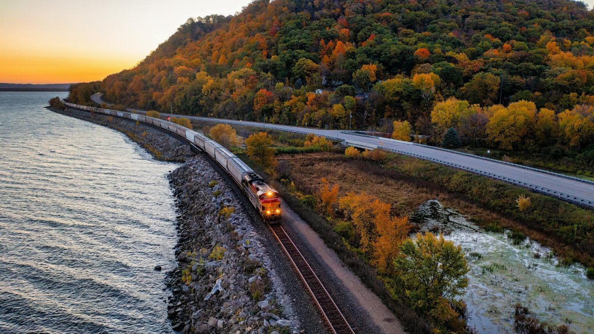 A scenic autumn train ride along a lake in Reads Landing, Minnesota, surrounded by vibrant fall foliage.