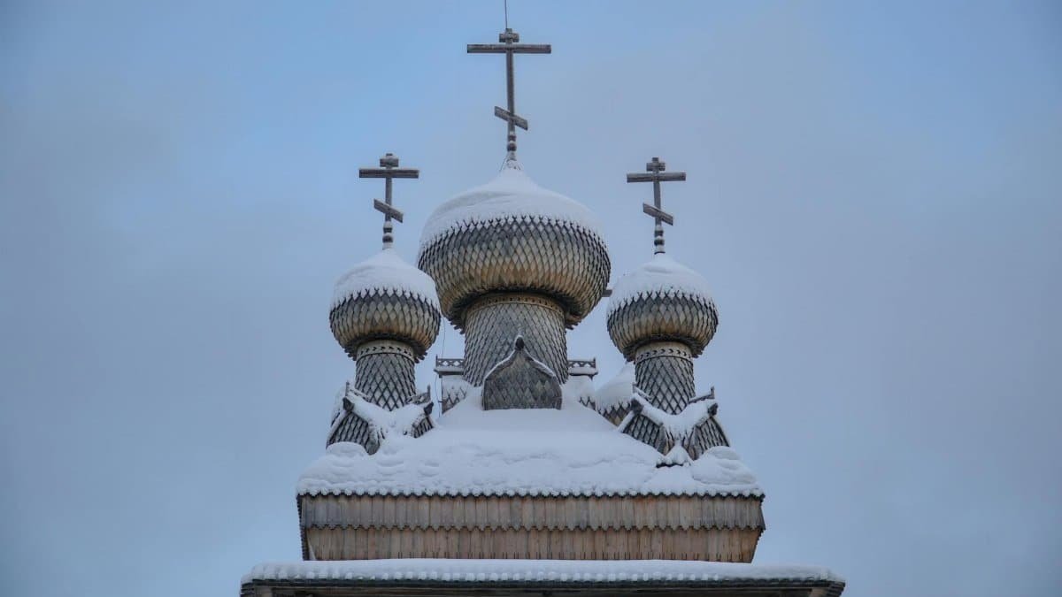 A snow-covered Russian Orthodox church in Arkhangelsk, showcasing traditional wooden architecture.