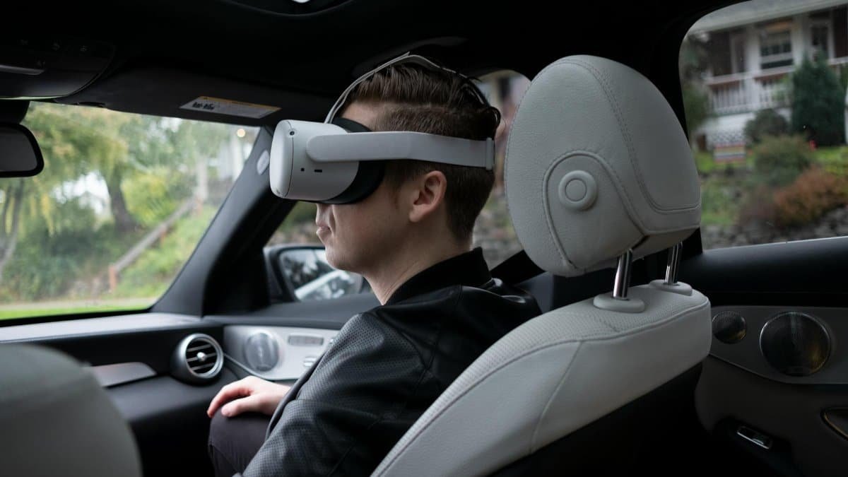 A man wearing VR goggles inside a luxury car, enjoying a virtual reality experience.