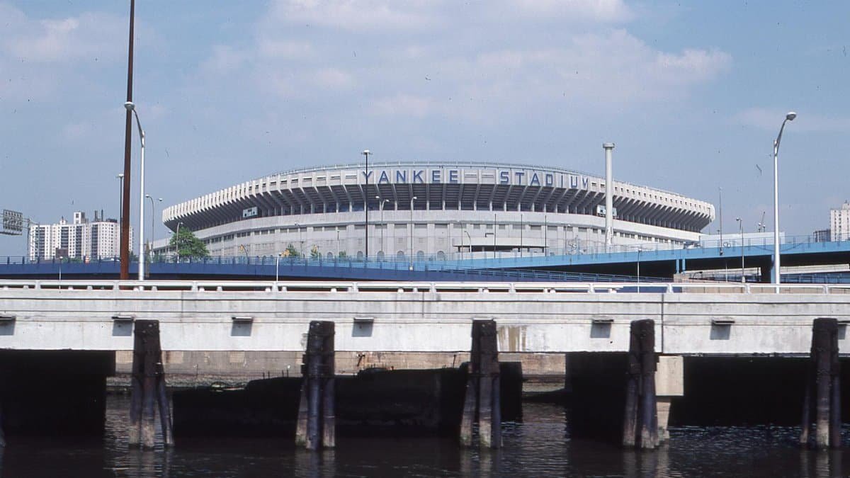 A scenic view of Yankee Stadium visible from a nearby waterfront bridge in New York.