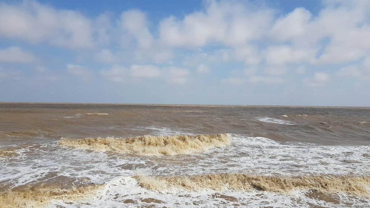 Peaceful ocean view with waves near Walton-on-the-Naze, England under a clear sky.