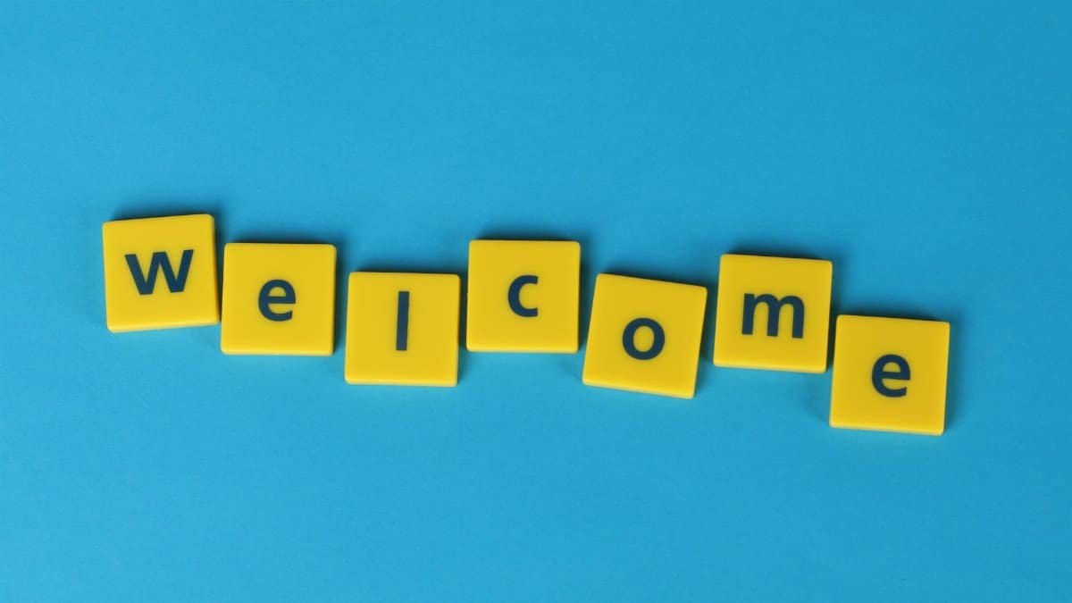 Yellow tiles spelling 'welcome' on a blue background, perfect for greetings.