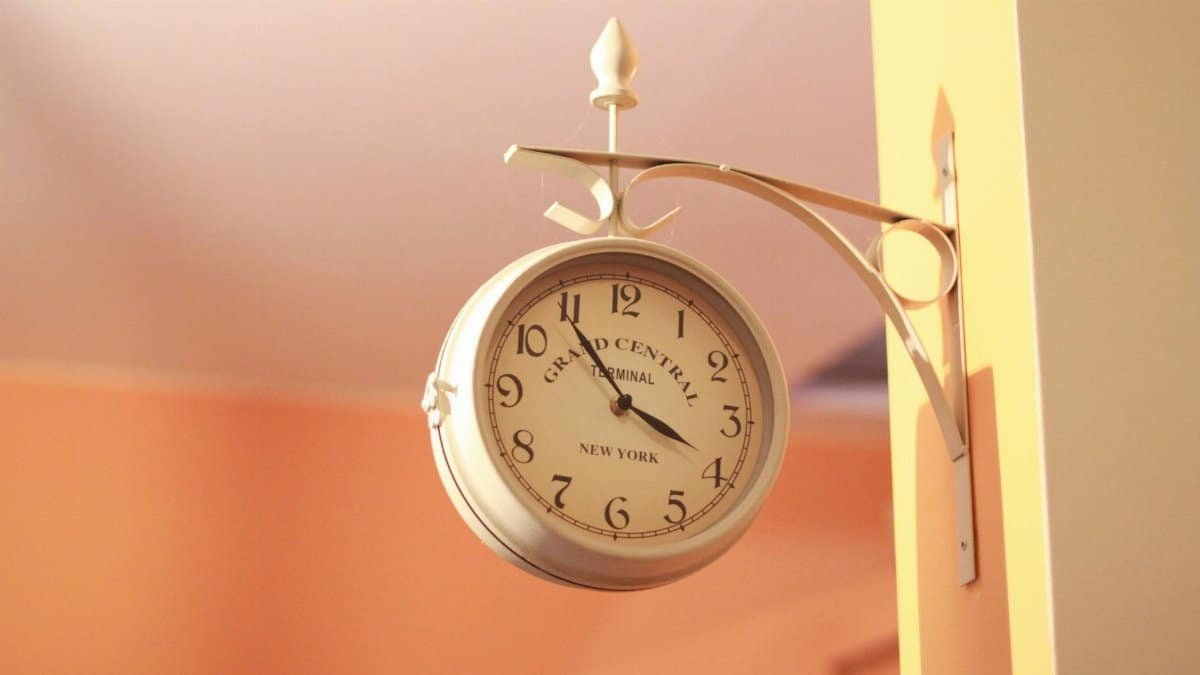 Elegant vintage wall clock mounted on a peach wall, reminiscent of Grand Central Terminal.