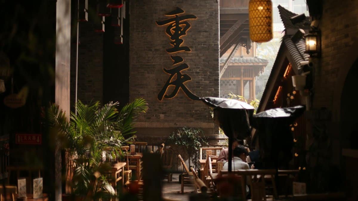 Cozy outdoor cafe in a traditional Chinese alley with warm lighting and cultural decor.