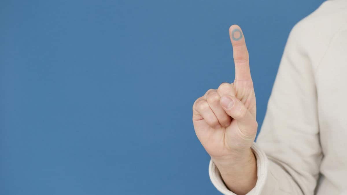 A hand gesture symbolizing diabetes awareness with a blue circle on a blue background.