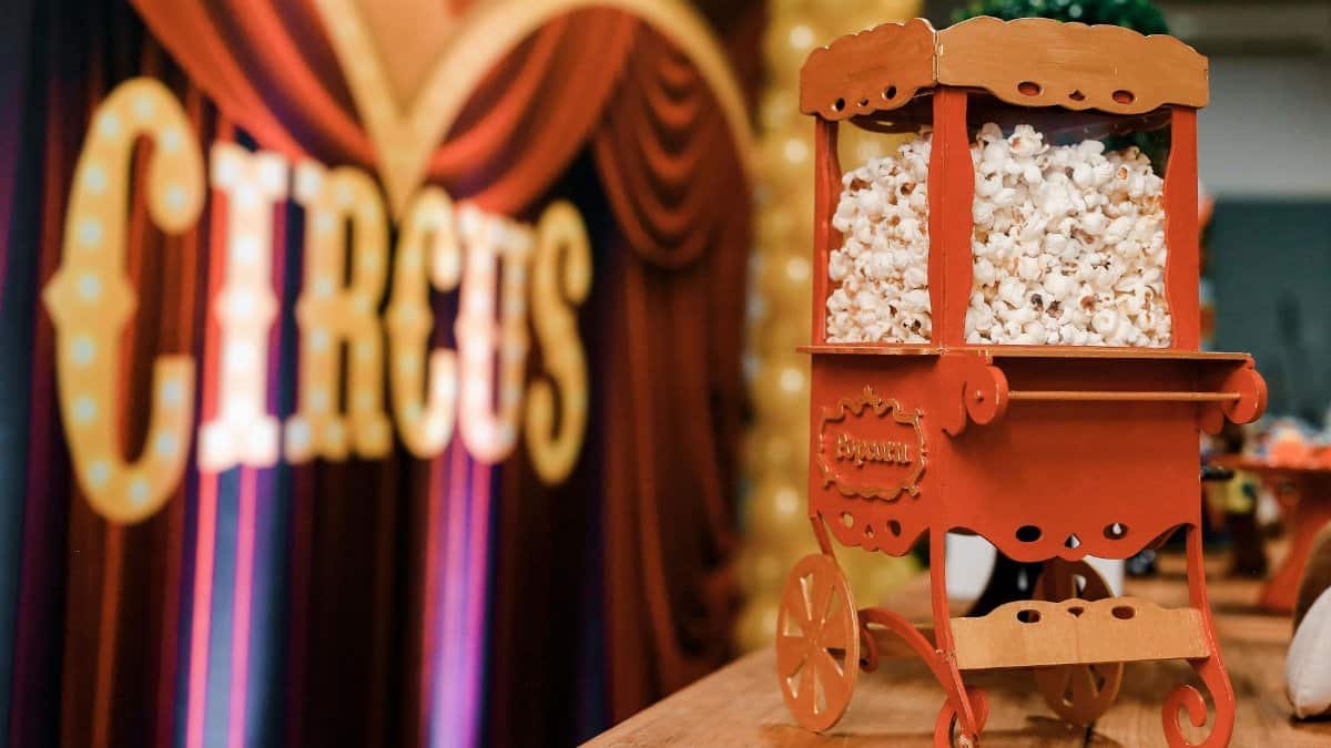 Close-up of a vintage popcorn cart at a circus-themed event, evoking nostalgia and excitement.