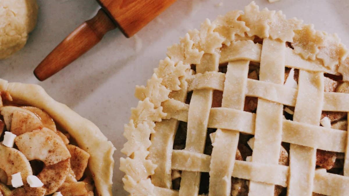 Delicious homemade apple pie with lattice crust in a cozy baking setting.