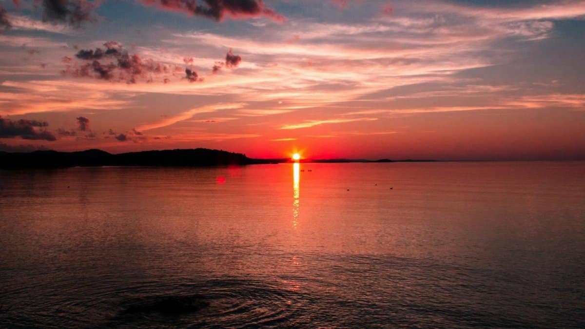 Breathtaking sunset over Lake Superior with vibrant sky and sea reflection in Marquette, MI.