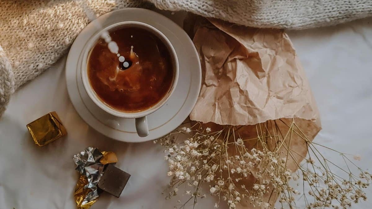 Warm and cozy still life with coffee, chocolate, and dried flowers for a serene autumn vibe.