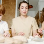 A mother and two children engaging in arts and crafts at home, fostering creativity and connection.