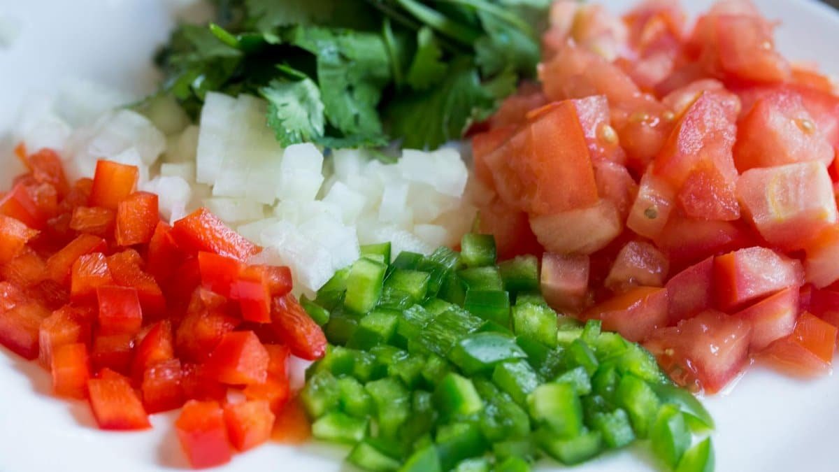 Colorful diced vegetables on a plate, perfect for healthy cooking and meal prep.
