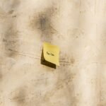 A yellow sticky note with 'You Can' written, placed on a textured outdoor wall.