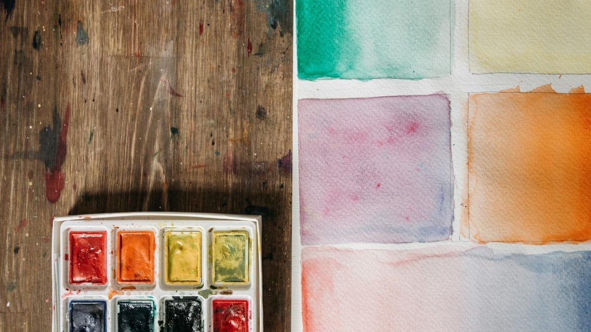 A watercolor palette with various color swatches on paper, ideal for artistic projects.