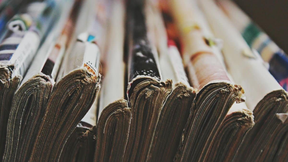 A detailed close-up image of a stack of magazines arranged in a row, showcasing their bindings.