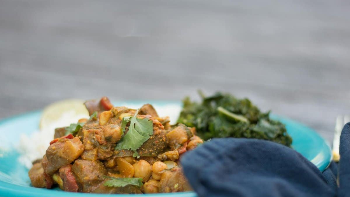 Savor a rich and flavorful Indian curry served with rice on a vibrant blue plate.