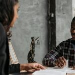 Business meeting between a lawyer and client in a professional office setting.