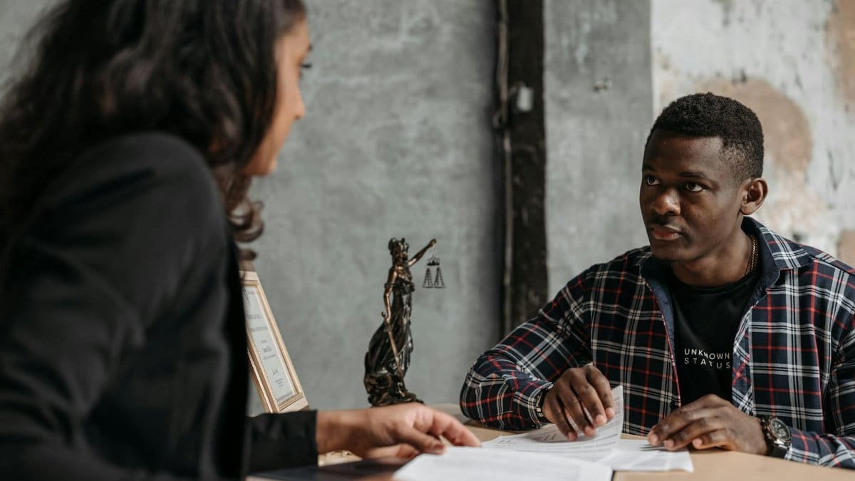 Business meeting between a lawyer and client in a professional office setting.