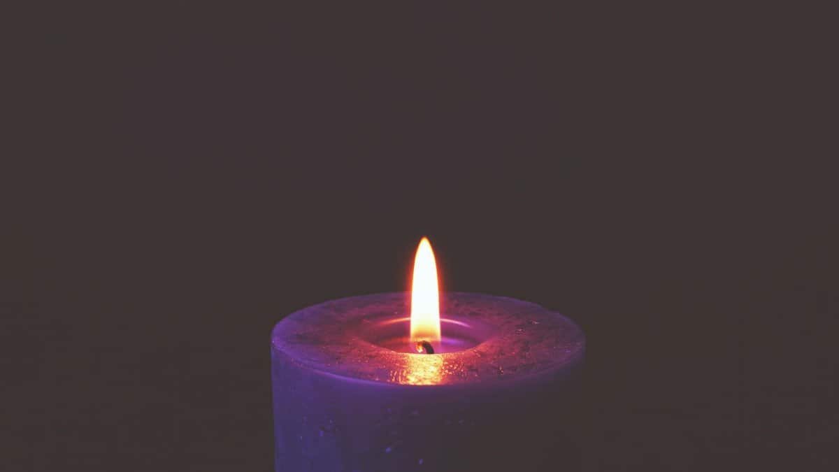 A soothing candle flame glowing in darkness, creating a peaceful mood.