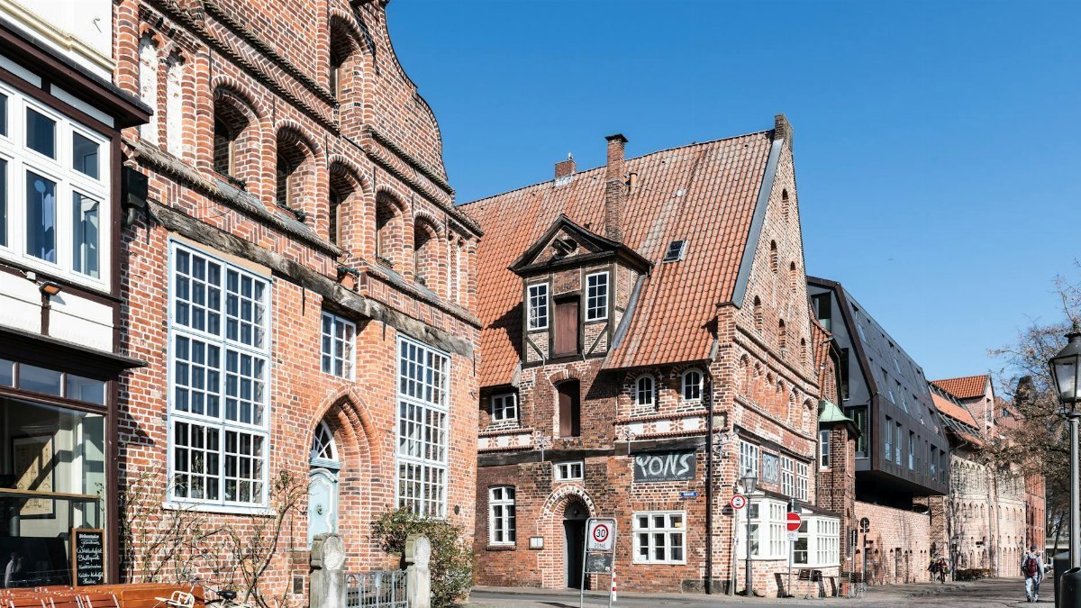 Explore the scenic medieval architecture of Lüneburg's historic center under a bright sky.