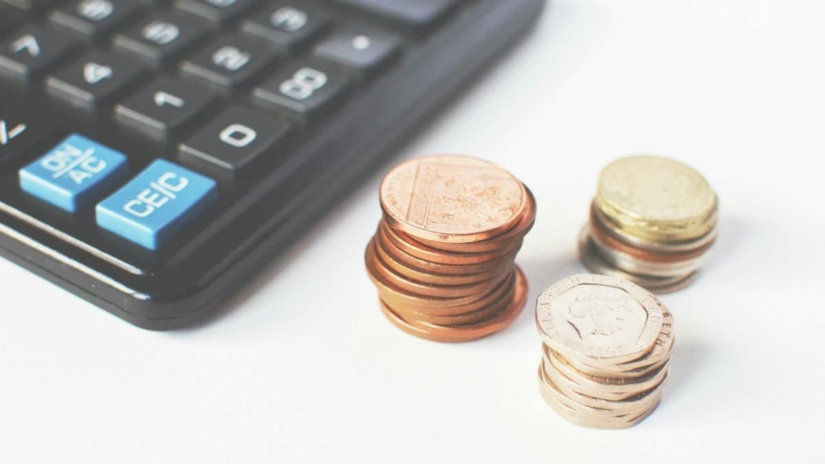 Close-up of stacked coins and a calculator symbolizing financial strategy and budgeting.