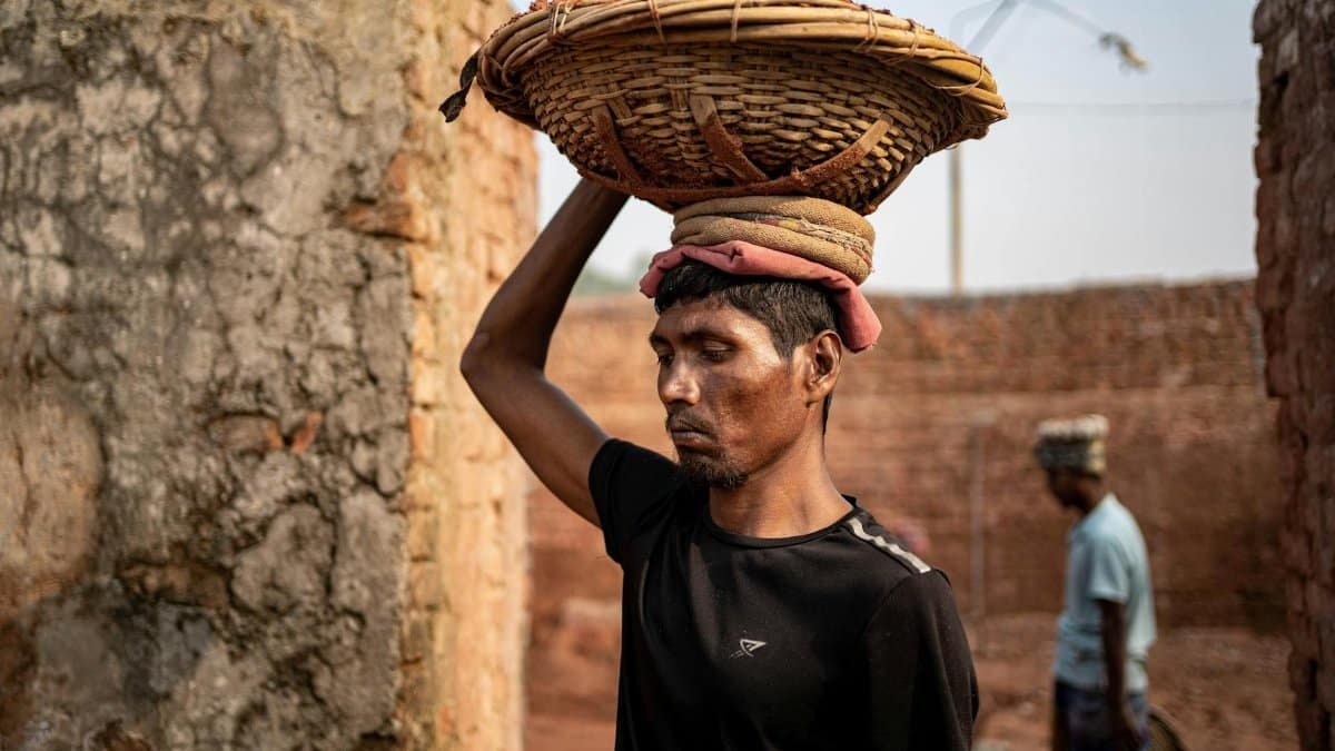A laborer carries bricks at a brick field in Dhaka Division, Bangladesh, symbolizing hard work and perseverance.