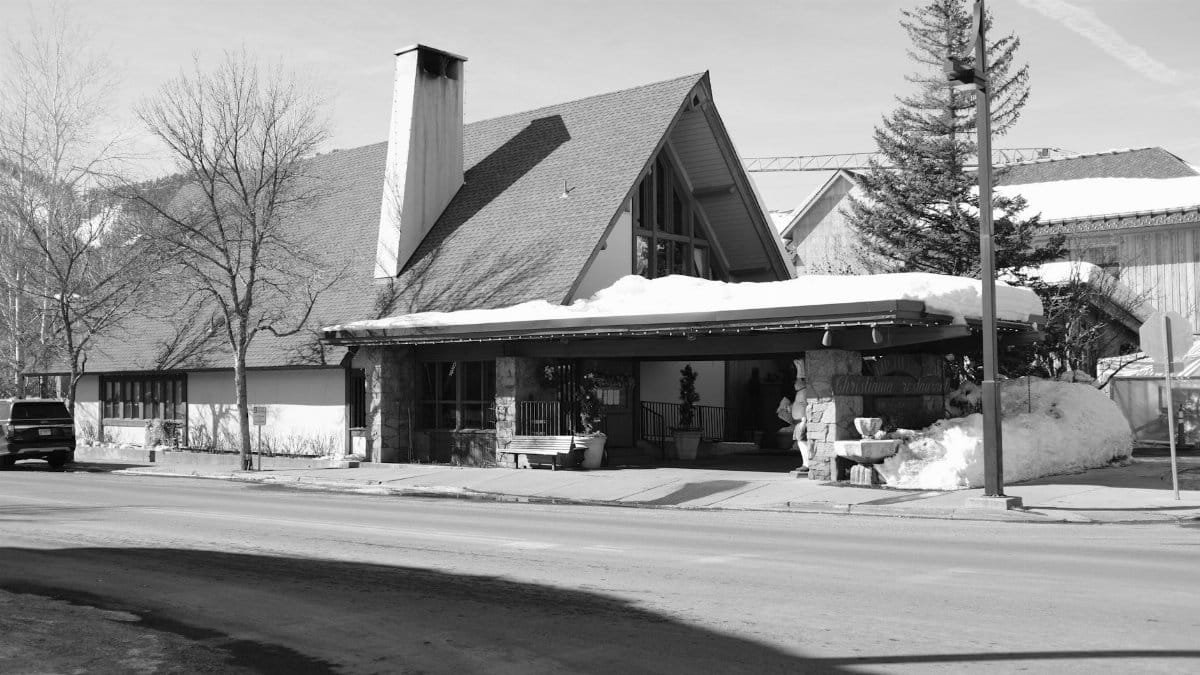 Black and white photo capturing a snow-covered building on a street in Ketchum, Idaho.
