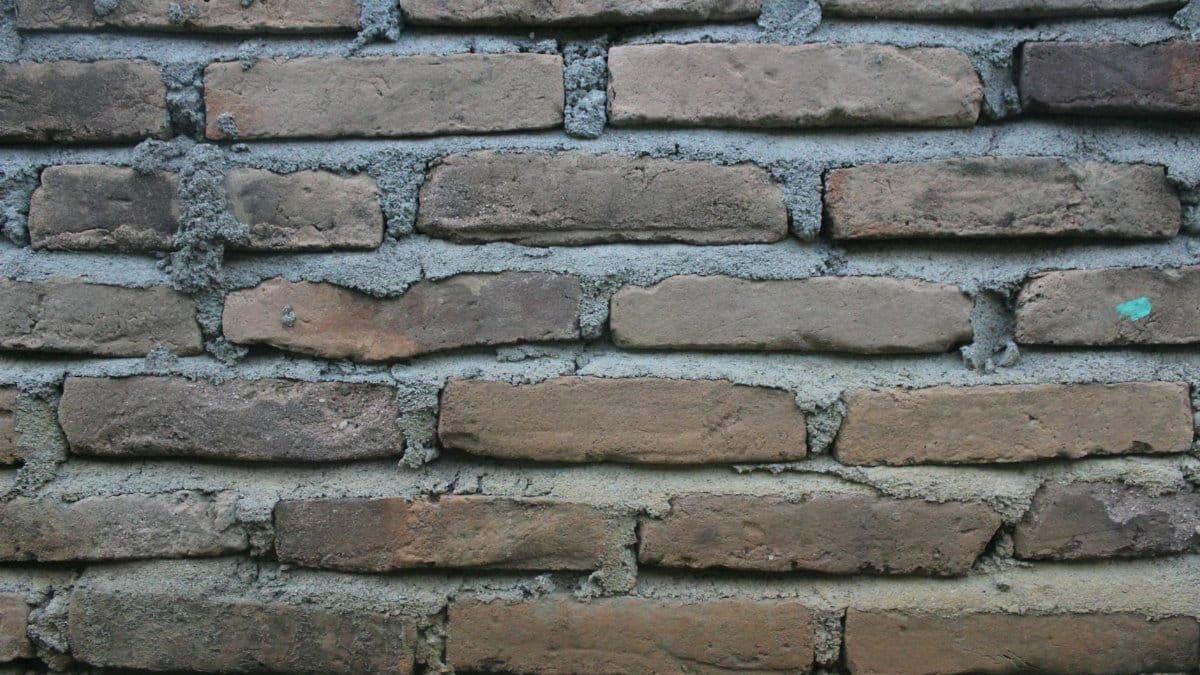 Close-up of a weathered brick wall showing rustic texture, ideal for backgrounds.