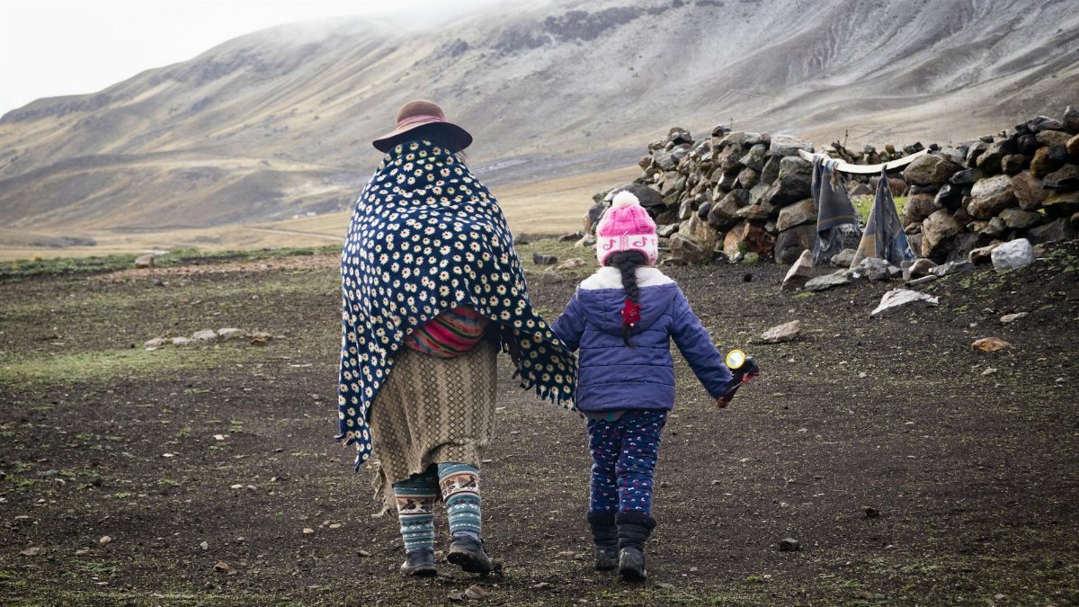 A mother and child stroll through the scenic highlands of Arequipa, Peru.