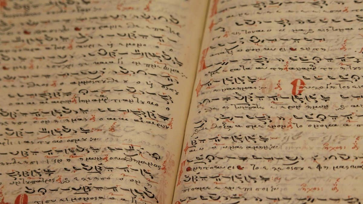 Close-up of an ancient manuscript with handwritten texts and ink inscriptions.