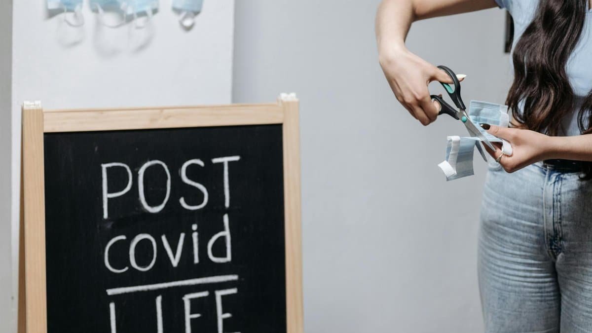 Symbolic image of cutting face mask representing post-pandemic life transition.