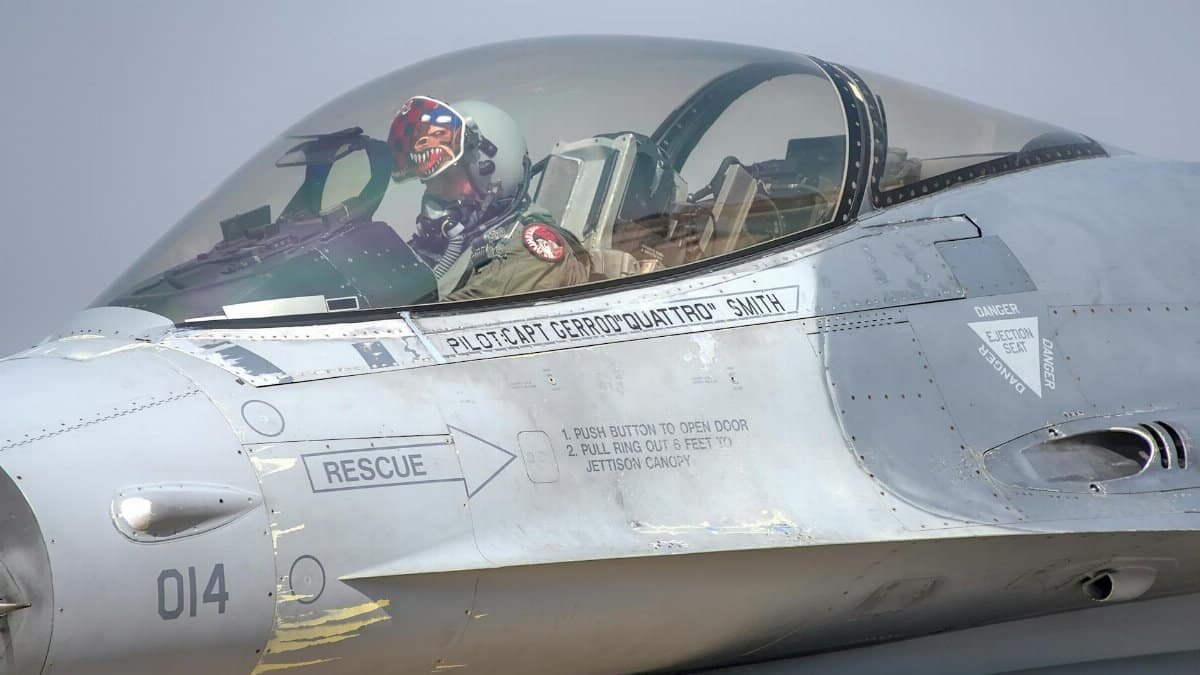 Close-up of a jet fighter cockpit with a pilot at the Bengaluru Air Show, showcasing the aircraft details and pilot gear.